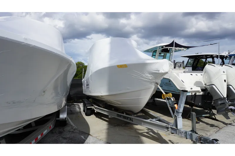 Slide: The Image of 2027 Regulator 23 boat wrapped in protective cover on trailer, parked outdoors. - 1