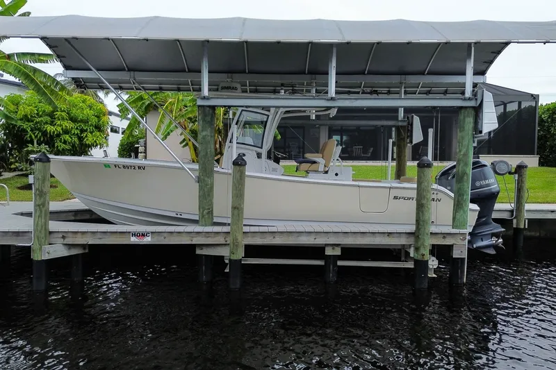 Slide: The Image of 2018 Sportsman Open 282 Center Console boat docked under a canopy. - 2