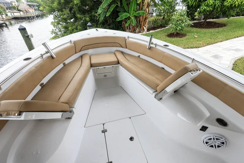 Slide: The Image of 2018 Sportsman Open 282 Center Console boat with tan seating, docked near lush greenery. - 13
