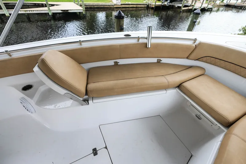 Slide: The Image of 2018 Sportsman Open 282 Center Console boat with tan cushioned seating by the water. - 15