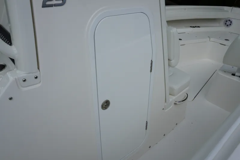 Slide: The Image of 2027 Regulator 25 boat interior with white seating and storage compartment. - 19