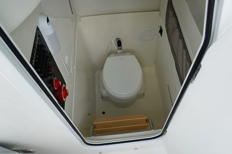 Slide: The Image of Interior of 2027 Regulator 25 boat featuring a compact marine toilet setup. - 20