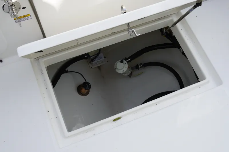 Slide: The Image of Open storage compartment on 2027 Regulator 25 boat, showing internal components and wiring. - 8