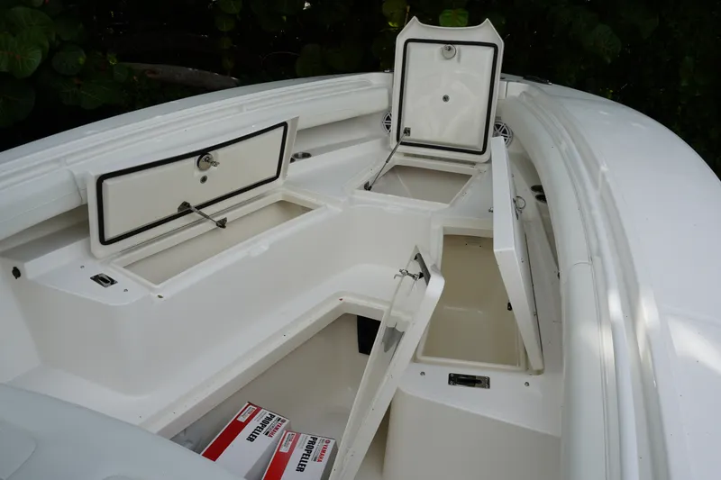Slide: The Image of 2027 Regulator 25 boat with open storage compartments and sleek white design. - 15