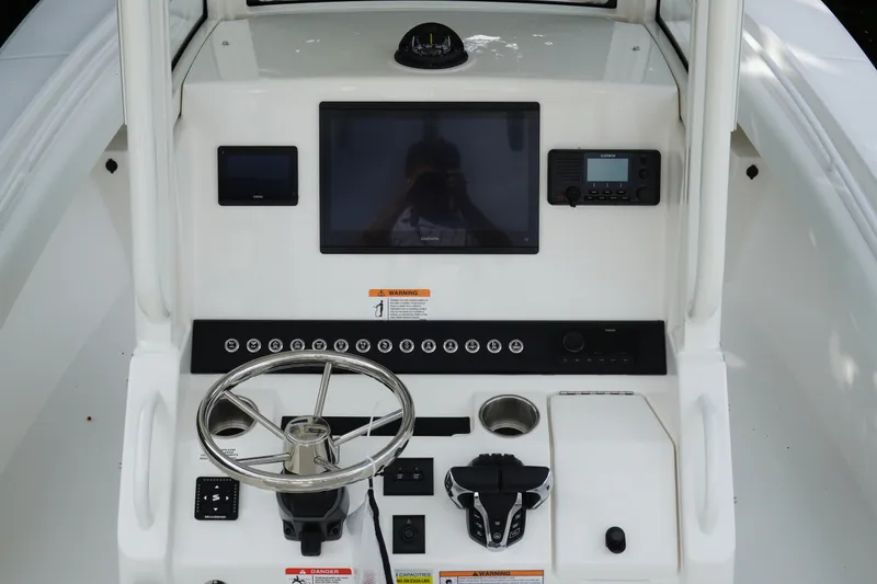 Slide: The Image of 2027 Regulator 25 boat dashboard with steering wheel, touchscreen, and control panel. - 12