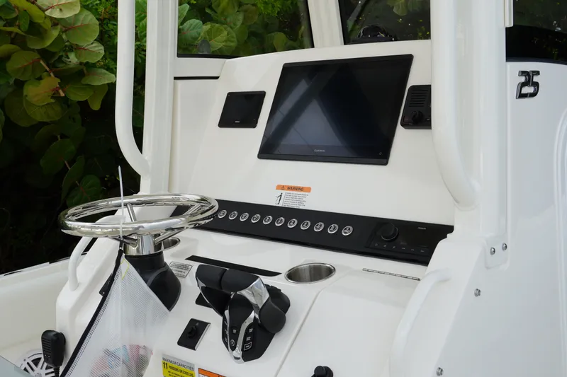 Slide: The Image of 2027 Regulator 25 boat dashboard with steering wheel and navigation screen. - 13