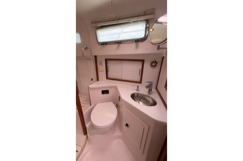 Slide: The Image of 2007 Sabre 34 Express yacht bathroom with toilet, sink, and storage cabinets. - 23