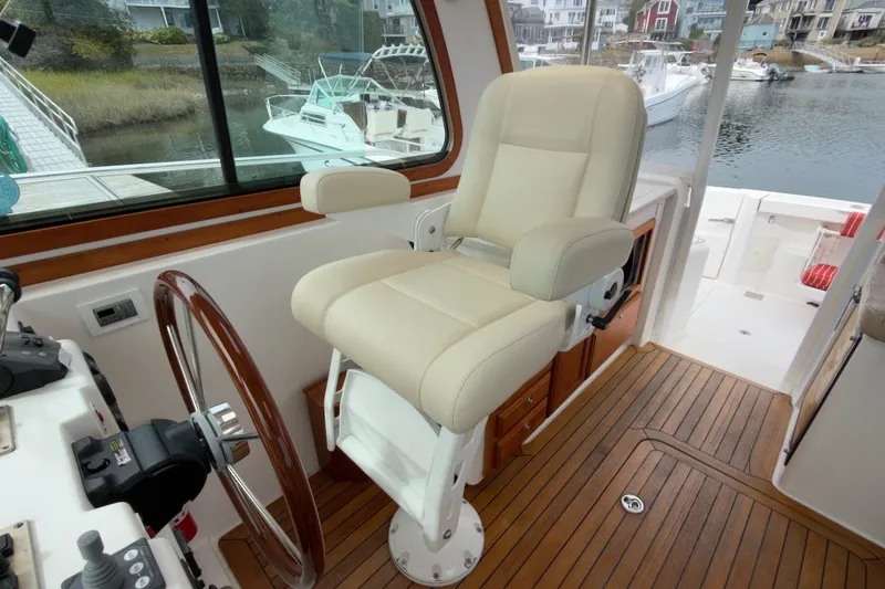 Slide: The Image of Captain's chair and helm of 2007 Sabre 34 Express boat with wooden accents. - 14