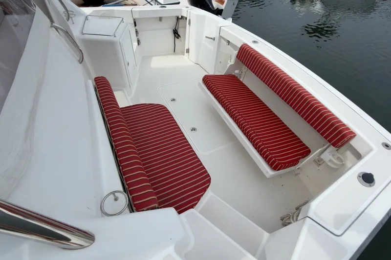 Slide: The Image of 2007 Sabre 34 Express boat interior with red-striped seating, docked on calm water. - 28