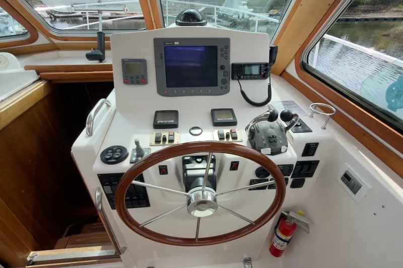 Slide: The Image of 2007 Sabre 34 Express helm with wooden steering wheel and navigation controls. - 9