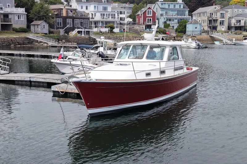 Slide: The Image of 2007 Sabre 34 Express boat docked in a scenic harbor with waterfront homes. - 3