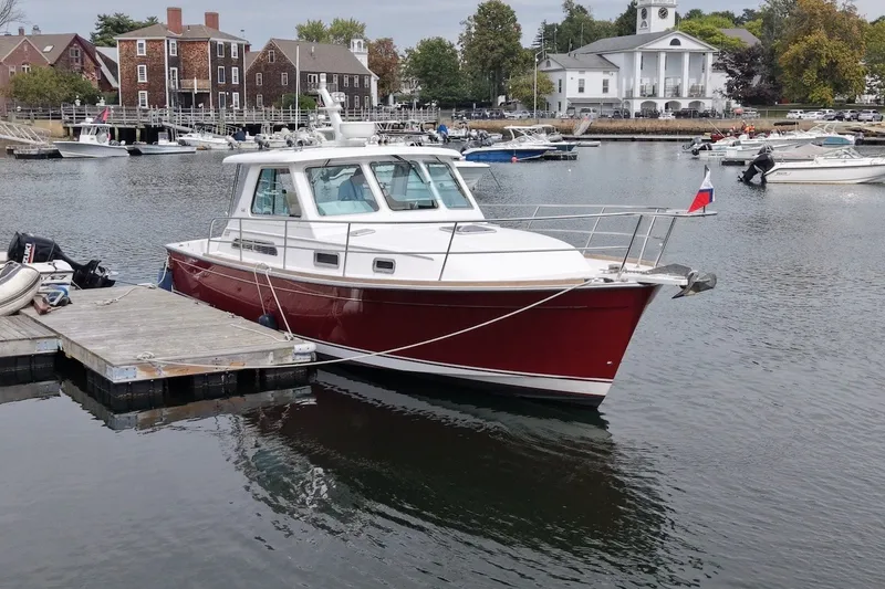 Slide: The Image of 2007 Sabre 34 Express boat docked in a scenic harbor setting. - 2
