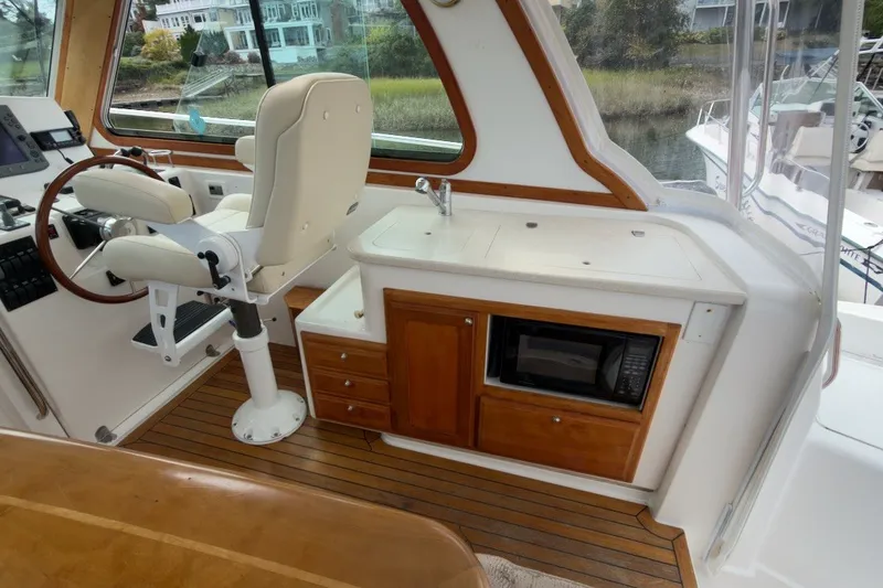 Slide: The Image of Interior of 2007 Sabre 34 Express yacht with helm, seating, and kitchenette. - 10