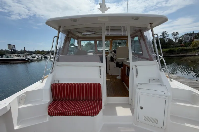 Slide: The Image of 2007 Sabre 34 Express boat with red-striped seating, docked by the water. - 24