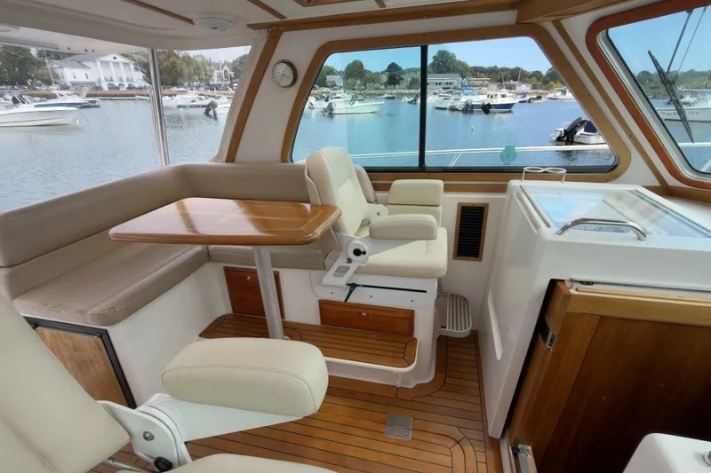 Slide: The Image of Interior of 2007 Sabre 34 Express yacht with seating and table, overlooking marina. - 12