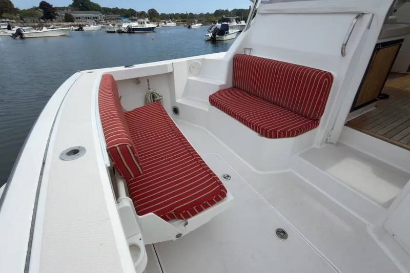 Slide: The Image of 2007 Sabre 34 Express boat with red-striped seating, docked in a marina. - 27