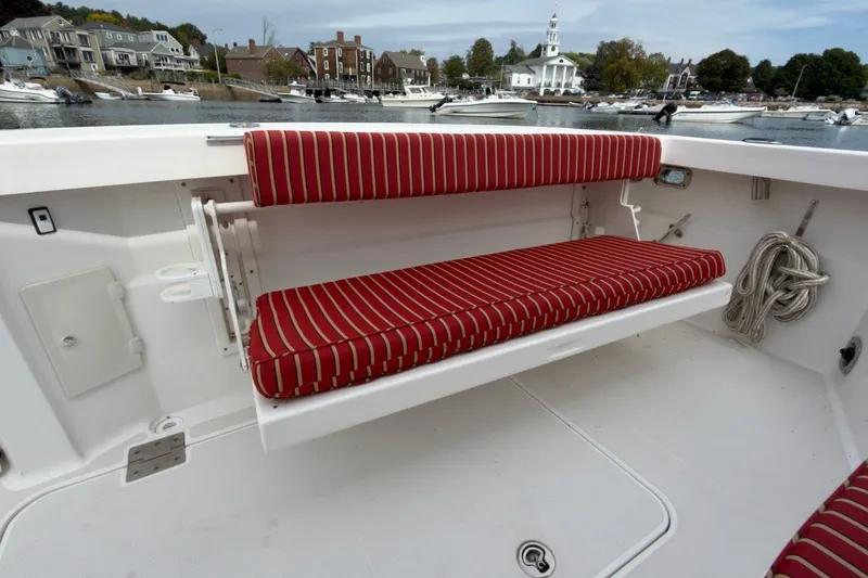 Slide: The Image of 2007 Sabre 34 Express boat with red-striped seating, docked near waterfront homes. - 29