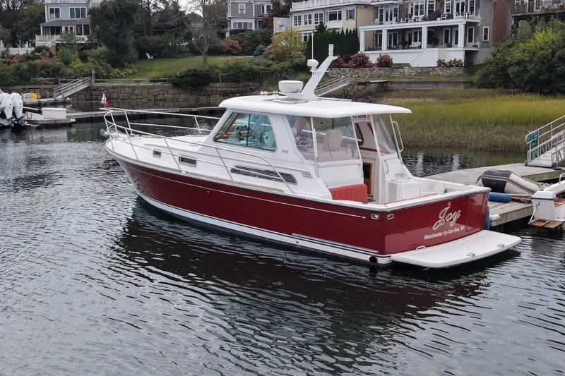 The Image of 2007 Sabre 34 Express boat docked in a scenic waterfront setting. - 0