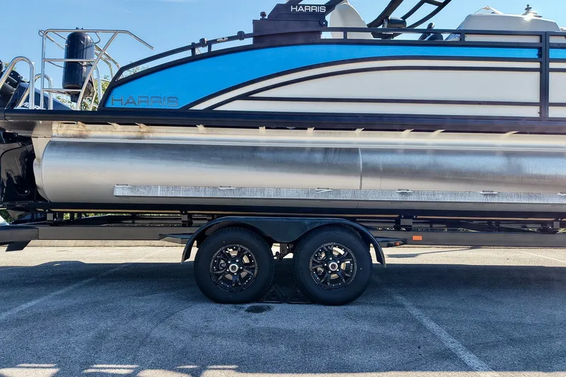 Slide: The Image of 2025 Harris Solstice 230 pontoon boat on trailer, side view in parking lot. - 60