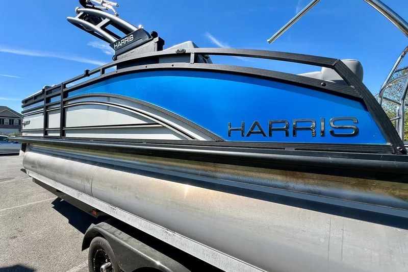 Slide: The Image of 2025 Harris Solstice 230 pontoon boat with sleek blue and silver design. - 20