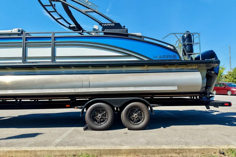 Slide: The Image of 2025 Harris Solstice 230 pontoon boat on trailer, parked in sunny lot. - 61