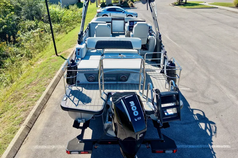 Slide: The Image of 2025 Harris Solstice 230 pontoon boat with Mercury 300 V8 engine, parked outdoors. - 13
