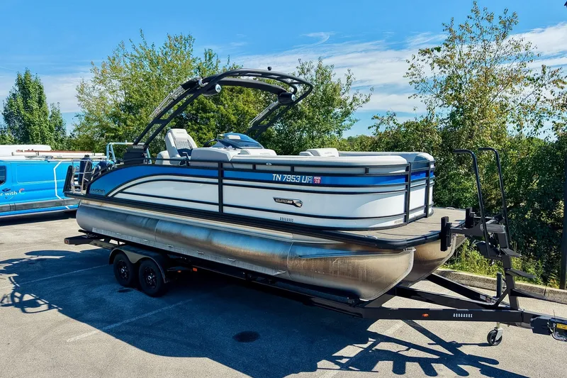 The Image of 2025 Harris Solstice 230 pontoon boat on trailer, parked outdoors. - 0