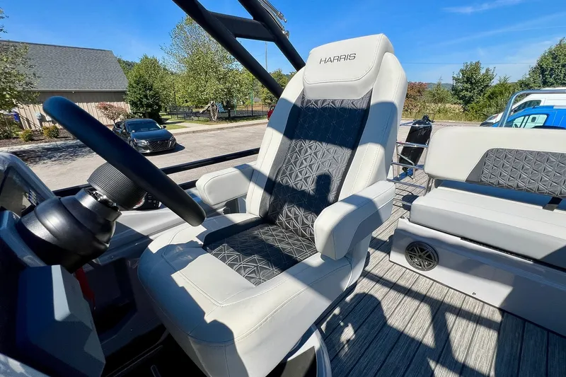 Slide: The Image of 2025 Harris Solstice 230 boat interior with luxurious captain's chair and steering wheel. - 34