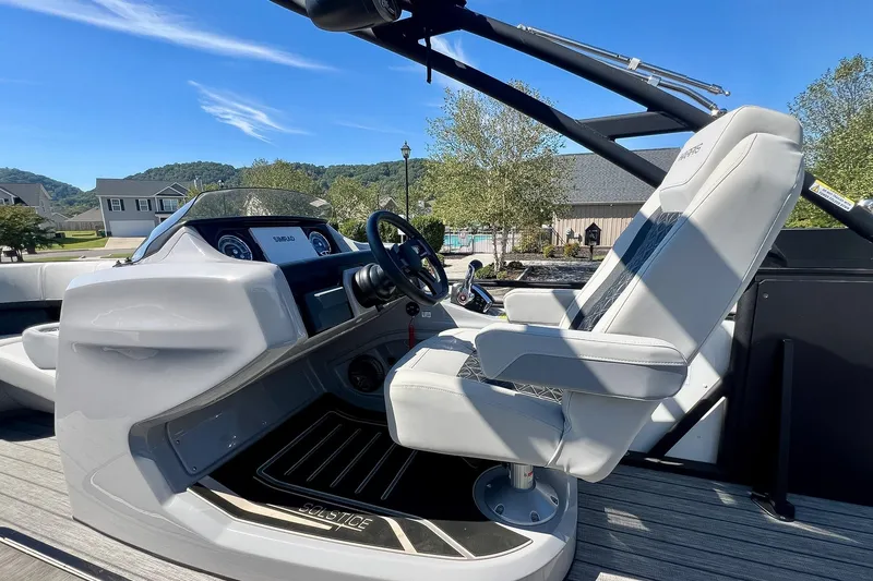 Slide: The Image of 2025 Harris Solstice 230 boat interior with captain's chair and dashboard controls. - 33