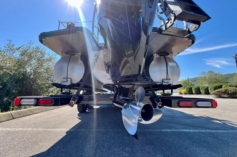 Slide: The Image of 2025 Harris Solstice 230 boat on trailer, rear view with propeller and sunlight. - 66