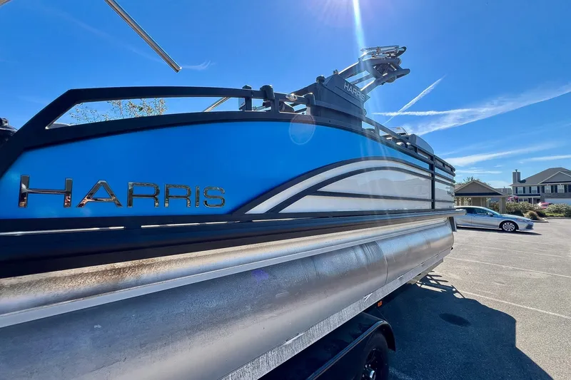 Slide: The Image of 2025 Harris Solstice 230 pontoon boat in a sunny parking lot. - 19