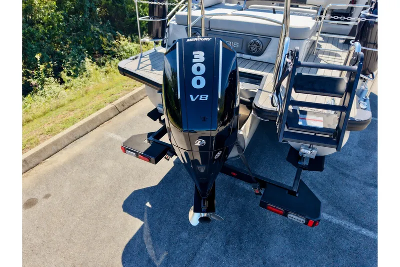 Slide: The Image of 2025 Harris Solstice 230 with Mercury 300 V8 outboard engine, parked on pavement. - 16