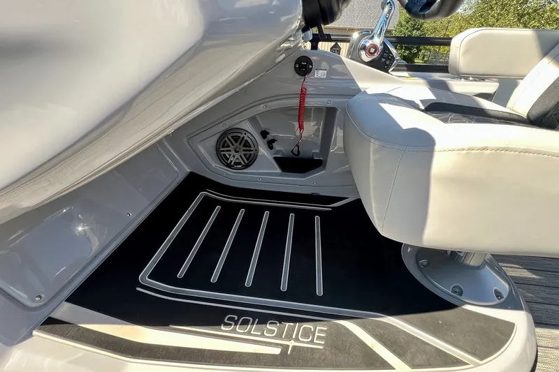 Slide: The Image of 2025 Harris Solstice 230 boat interior with steering wheel, seat, and branded floor mat. - 40
