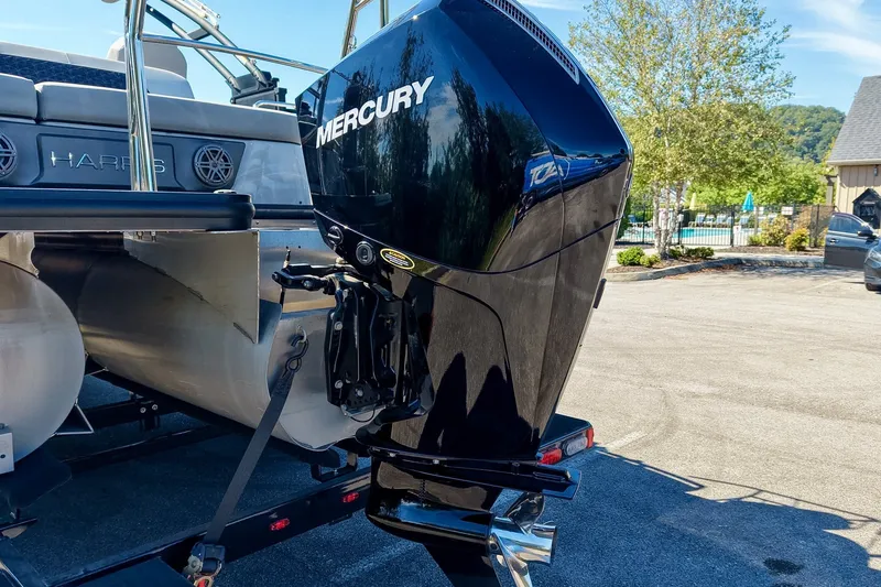 Slide: The Image of 2025 Harris Solstice 230 pontoon boat with Mercury outboard motor in a sunny outdoor setting. - 17