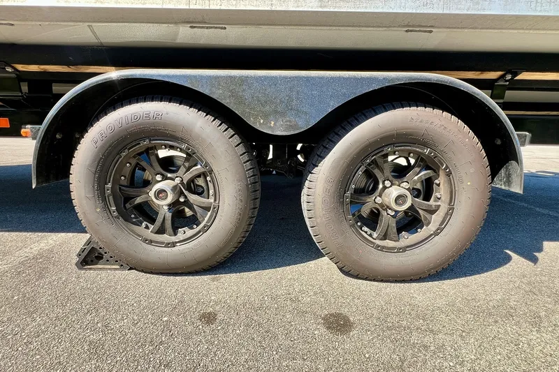 Slide: The Image of Trailer wheels of a 2025 Harris Solstice 230 boat on pavement. - 62