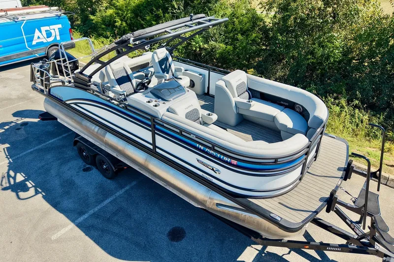 Slide: The Image of 2025 Harris Solstice 230 pontoon boat on trailer, parked outdoors. - 3