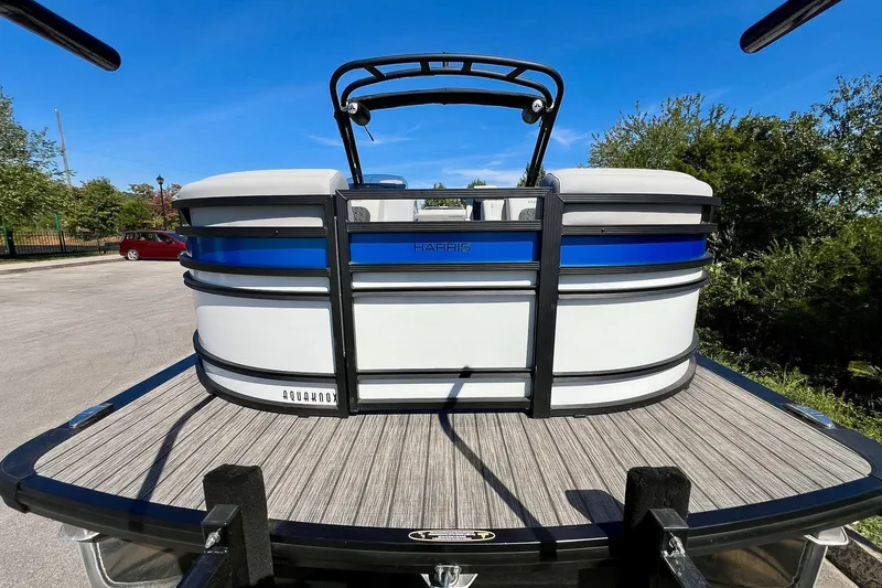 Slide: The Image of 2025 Harris Solstice 230 pontoon boat on trailer, parked outdoors under clear blue sky. - 22