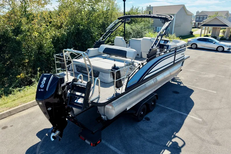 Slide: The Image of 2025 Harris Solstice 230 pontoon boat with powerful 300 V8 engine in a parking lot. - 15