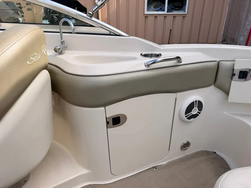 Slide: The Image of The image shows the cockpit of a 2006 Sea Ray 220 Sundeck with a sink and storage area. - 16