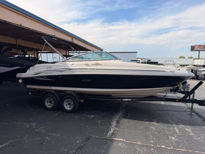 Slide: The Image of A 2006 Sea Ray 220 Sundeck on a trailer, parked under a covered area. - 2