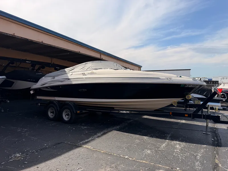 Slide: The Image of A 2006 Sea Ray 220 Sundeck on a trailer in a covered area. - 1