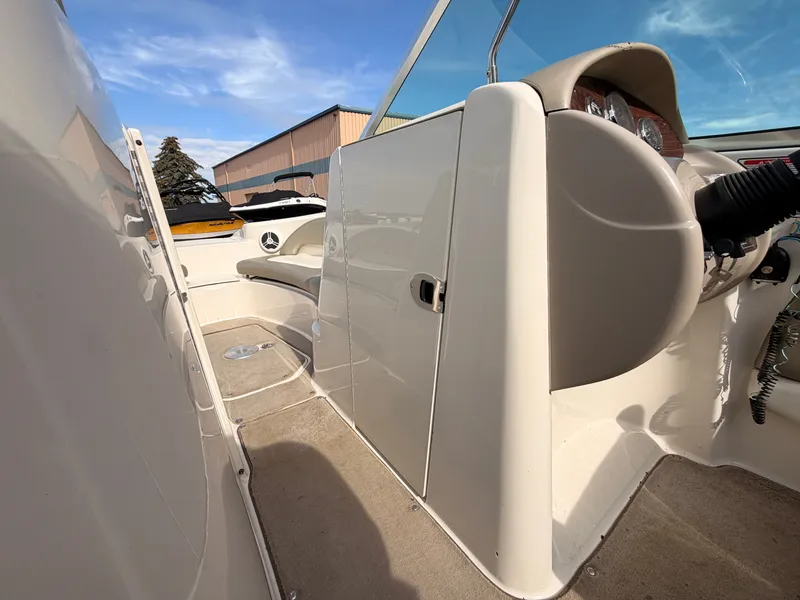 Slide: The Image of The image shows the cockpit of a 2006 Sea Ray 220 Sundeck with beige interior. - 36