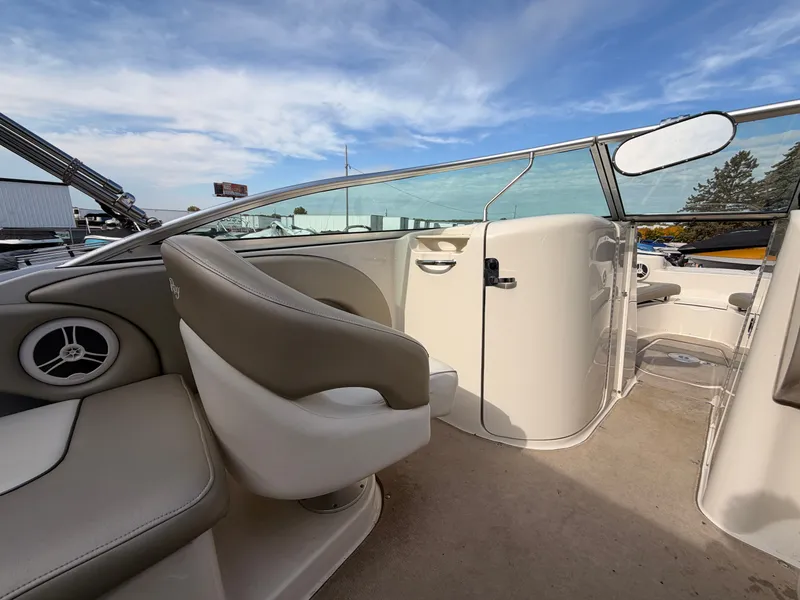 Slide: The Image of The image shows the cockpit of a 2006 Sea Ray 220 Sundeck boat with beige seating. - 19