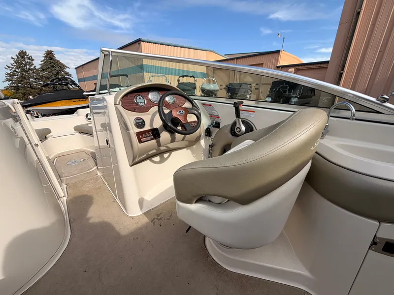 Slide: The Image of The image shows the cockpit of a 2006 Sea Ray 220 Sundeck with a beige steering wheel and dashboard. - 23