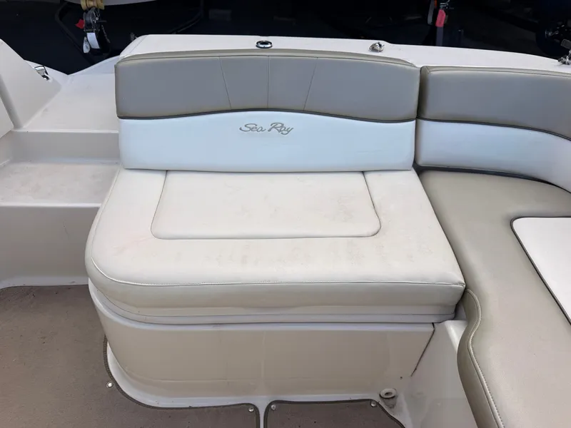 Slide: The Image of The 2006 Sea Ray 220 Sundeck features a cushioned bench seat with beige and white leather. - 11