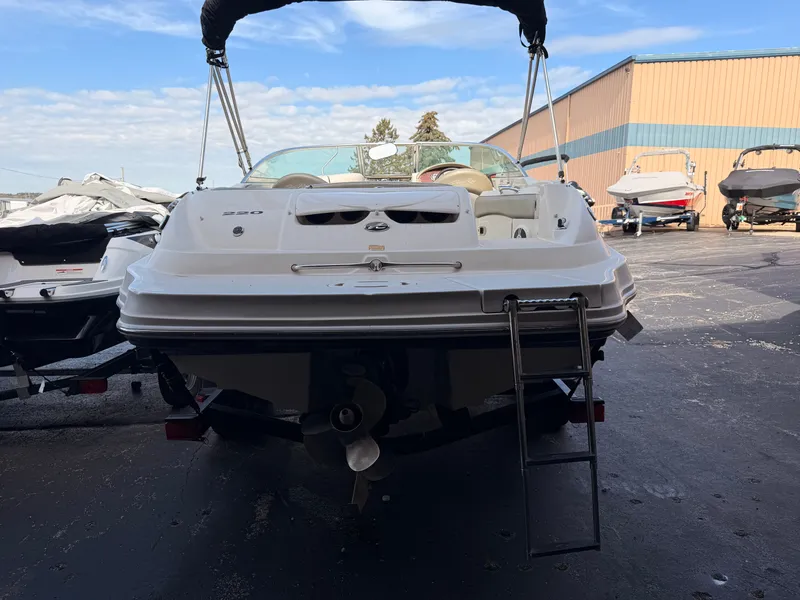Slide: The Image of A 2006 Sea Ray 220 Sundeck is parked. It features a swim ladder and a Bimini top. - 4
