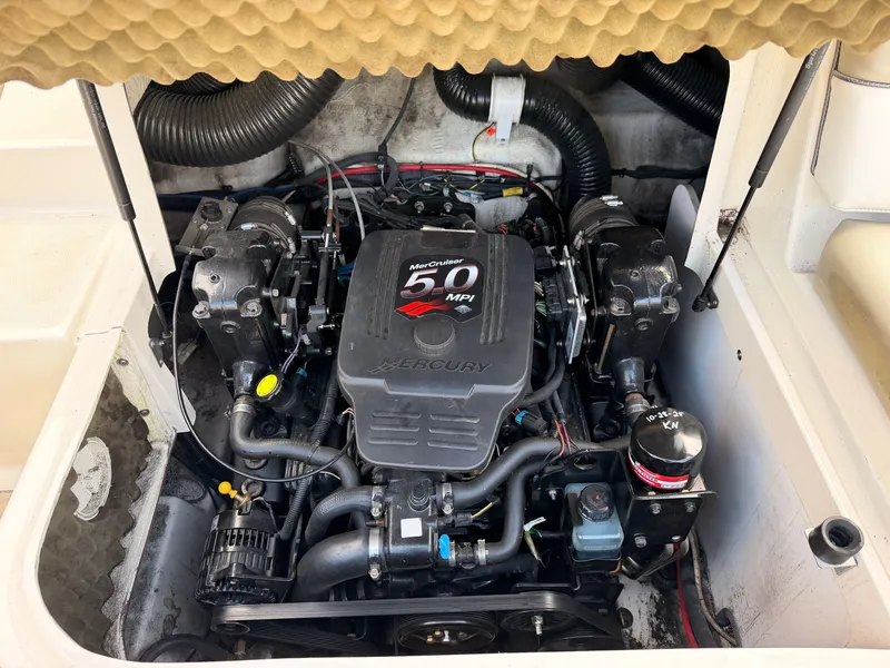 Slide: The Image of The engine compartment of a 2006 Sea Ray 220 Sundeck features a Mercury engine with 50 MPI. - 12