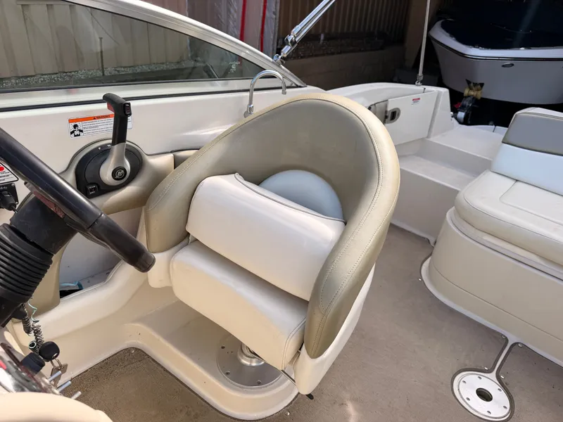 Slide: The Image of The image shows the helm of a 2006 Sea Ray 220 Sundeck with a beige seat. - 25