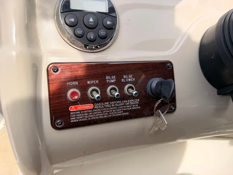 Slide: The Image of Close-up of the control panel with switches and warning labels on a 2006 Sea Ray 220 Sundeck. - 27