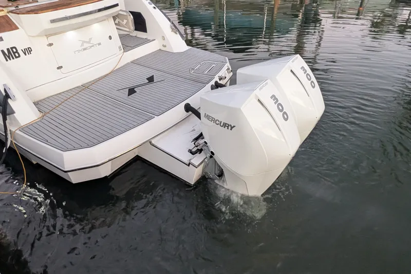 Slide: The Image of 2023 NX Boats 340 Sport Coupe with dual Mercury outboard engines on water. - 44